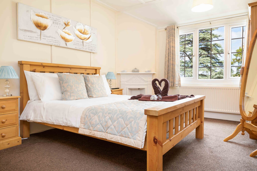 Oakcliff's Oak Cottage double bedroom. With a double bed and two towels in the shape of swans
