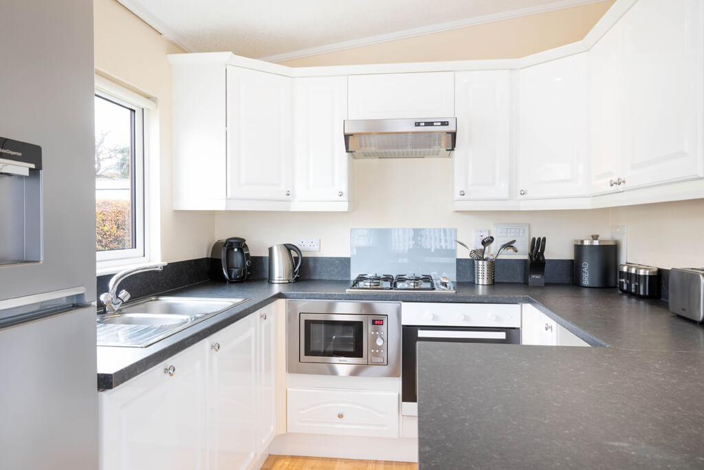 Oakcliff's Oak Lodge grey and white kitchen with a peninsula.