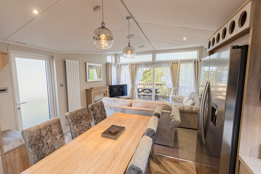 Oakcliff's Osprey Platinum Mini Lodge open-plan living area. Including the dining table and lounge