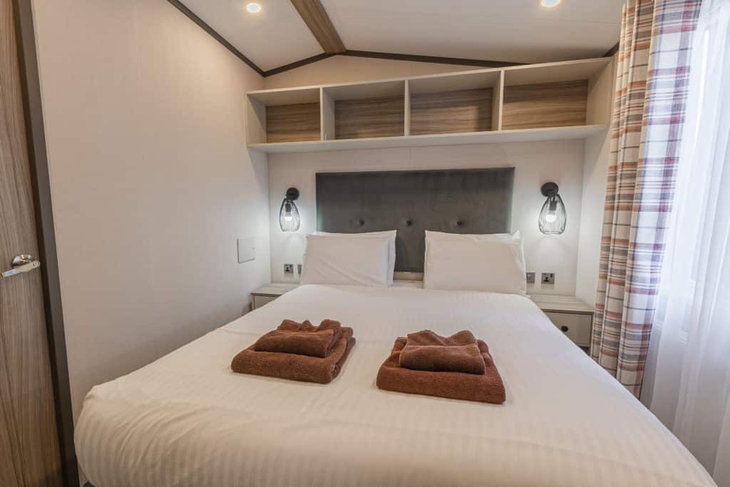 Oakcliff's Lapwing Mini Lodge double bedroom with overhead storage