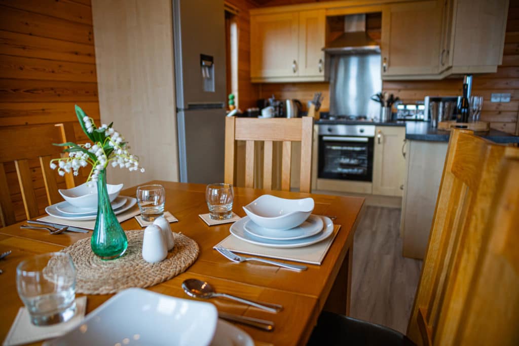 A set dining table with a kitchen in the background.