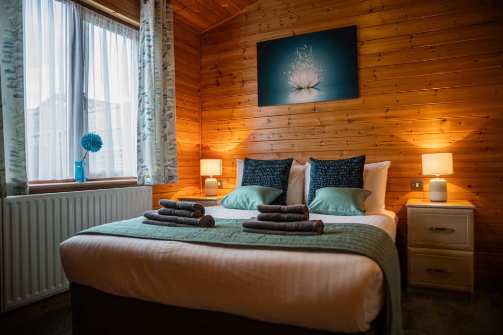 Oakcliff's Pine Lodge double bedroom. A warm, welcoming interior with plenty of natural light.