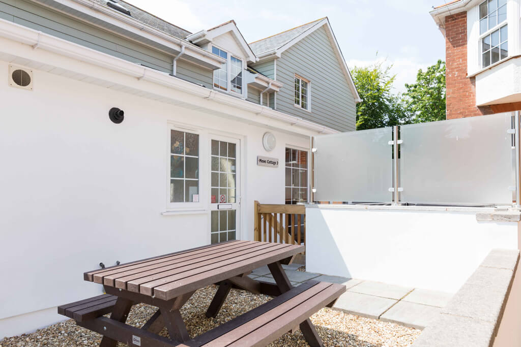 Oakcliff's Mews Cottage outdoor area/ Including the cottage itself and a picnic bench