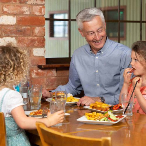 Grandparents and grandchildren eating dinner at a restaurant