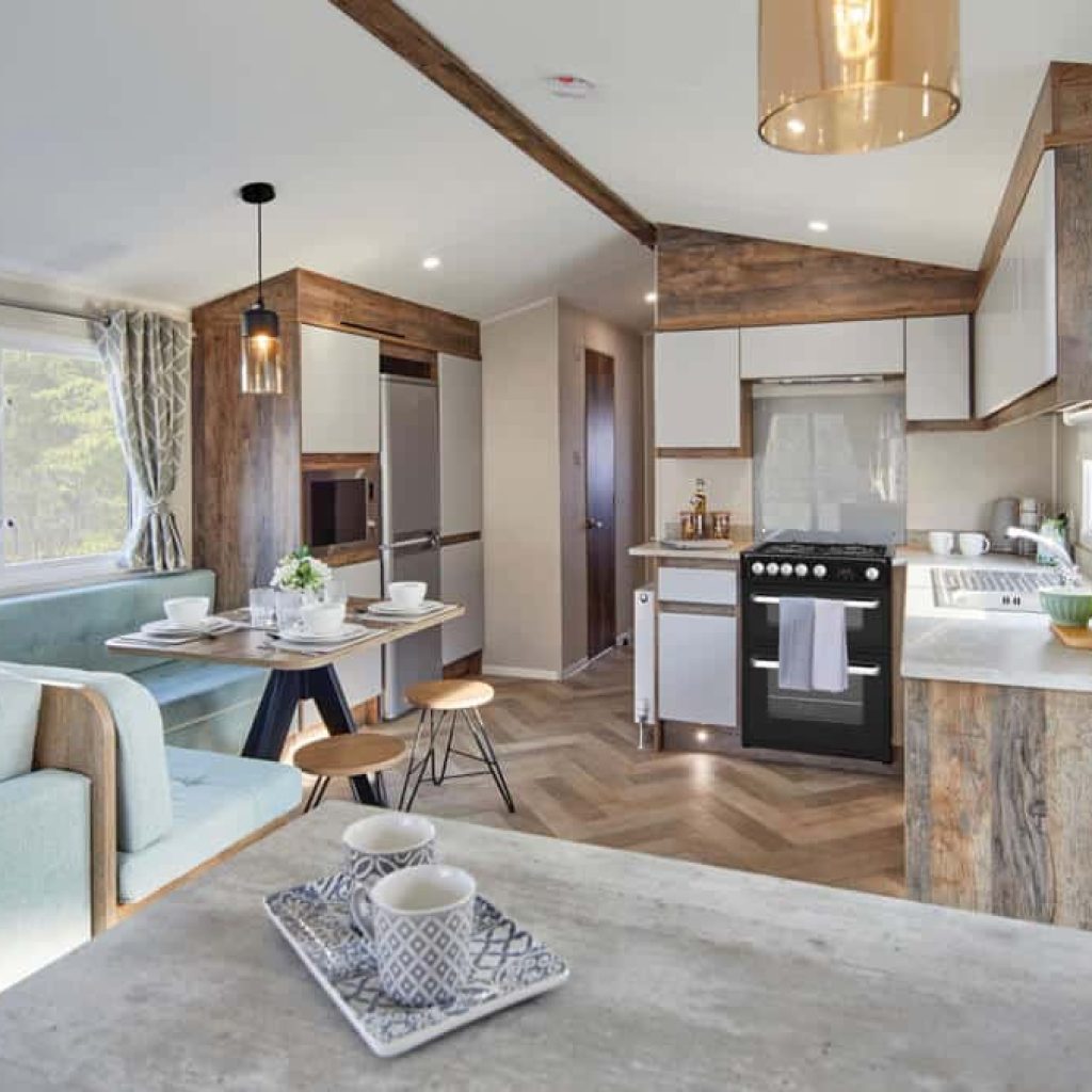 Oakcliff's Lapwing Plus Mini Lodge modern open-plan living area. Including a dining table, lounge and kitchen.