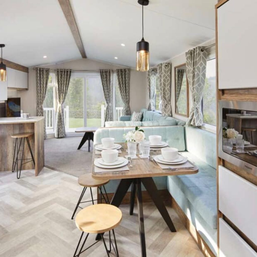Oakcliff's Lapwing Plus Mini Lodge modern open-plan living area. Showing a breakfast bar, dining table and lounge.