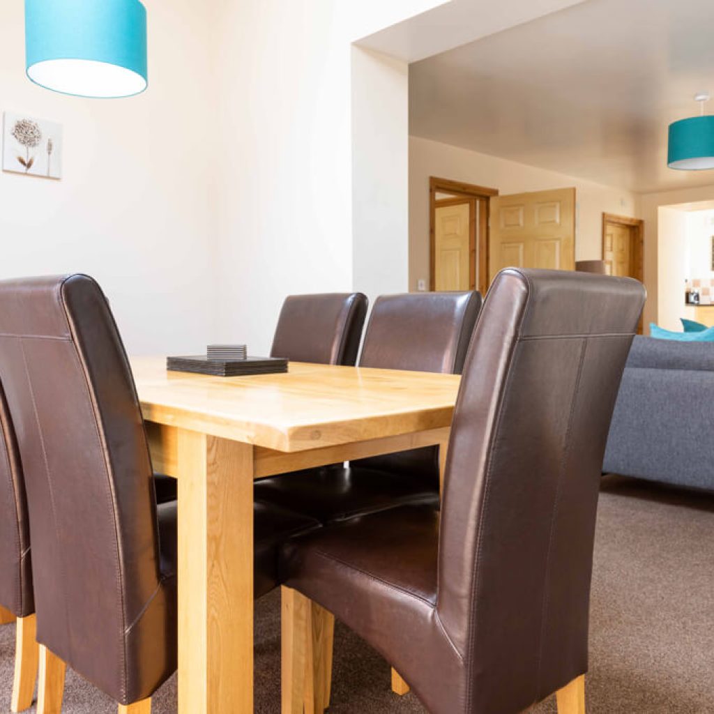 Oakcliff's Mews Cottage dining table. Consisting of a woden table and 6 brown, leather chairs.