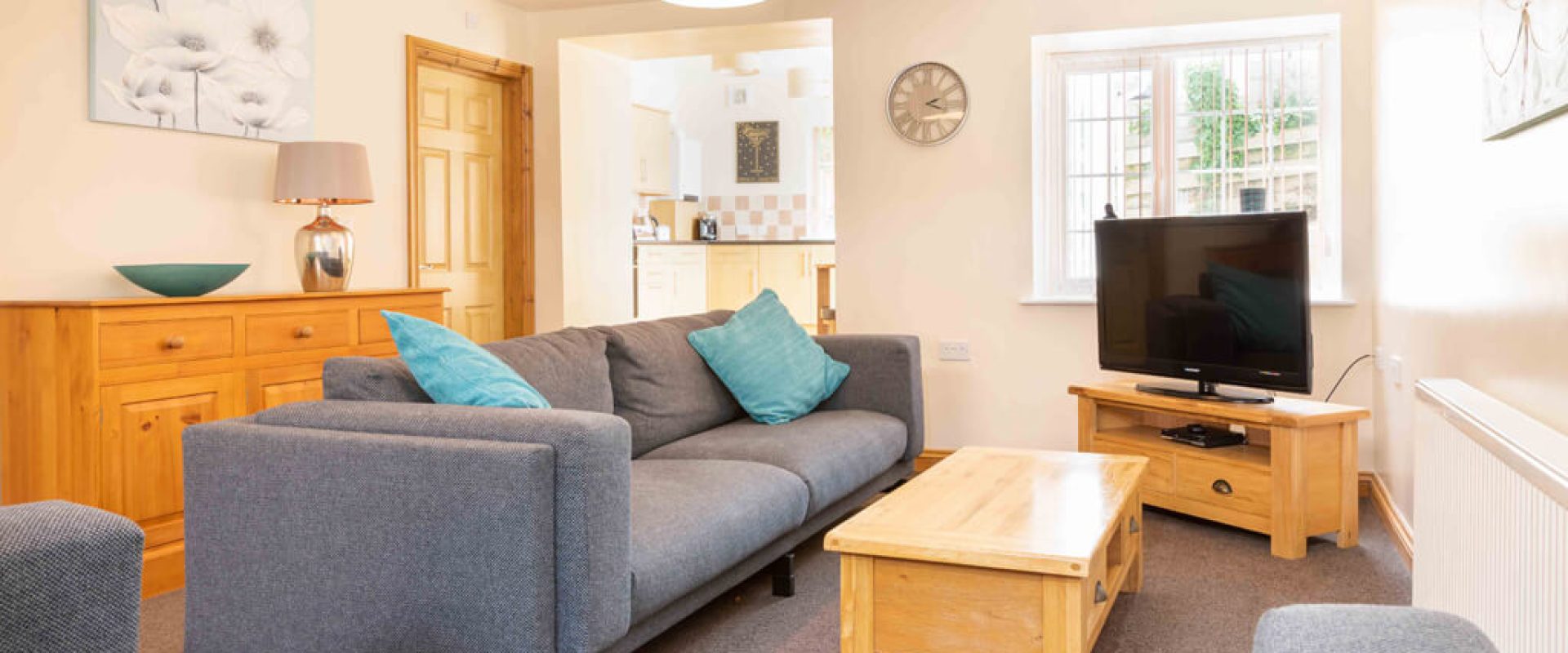 Oakcliff's Mews Cottage living room. With a stylish sofa, coffee table and TV.