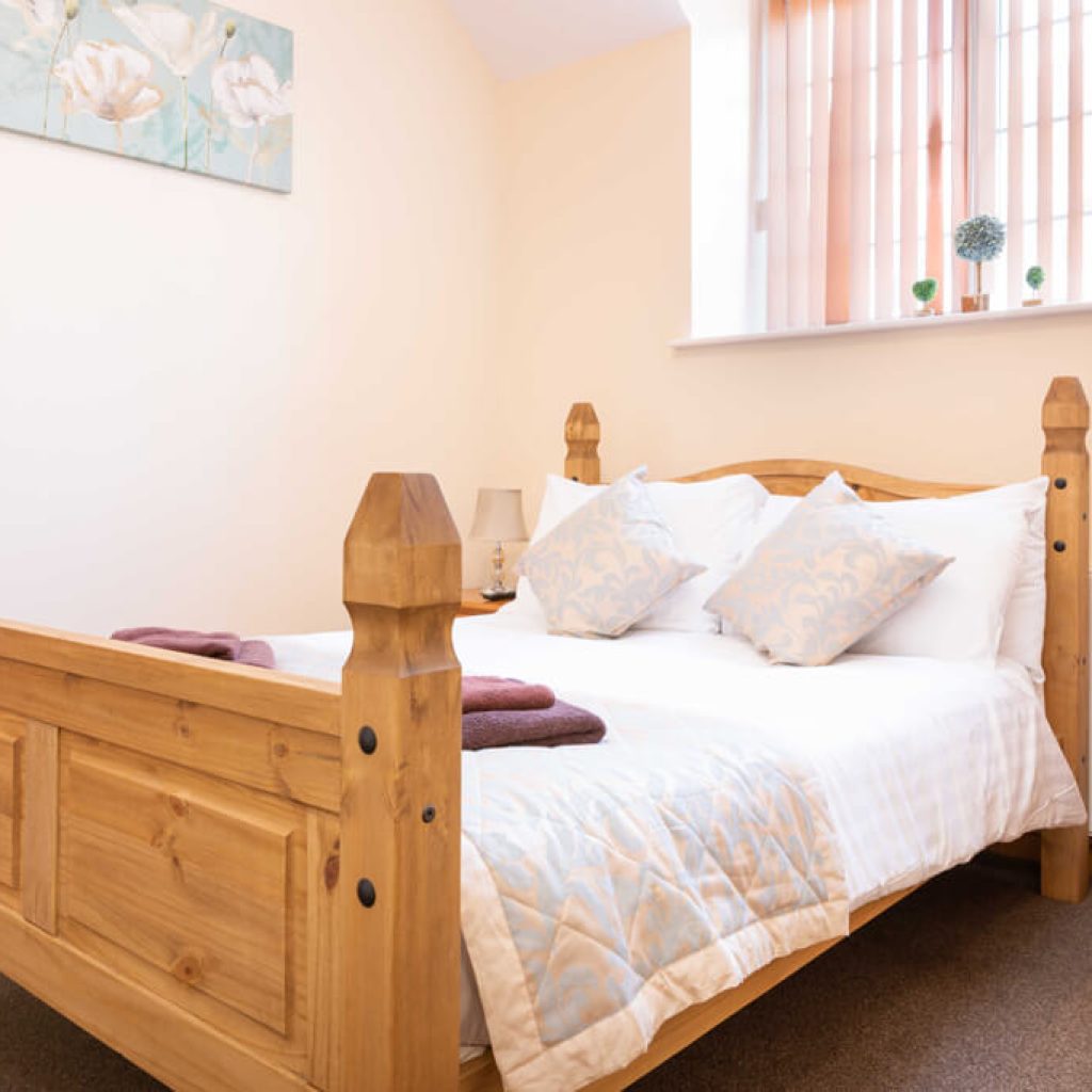 Oakcliff's Mews Cottage double bedroom. Including a sturdy, wooden bed with homely fittings.