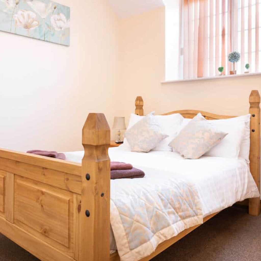 Oakcliff's Mews Cottage double bedroom. Including a sturdy, wooden bed with homely fittings.