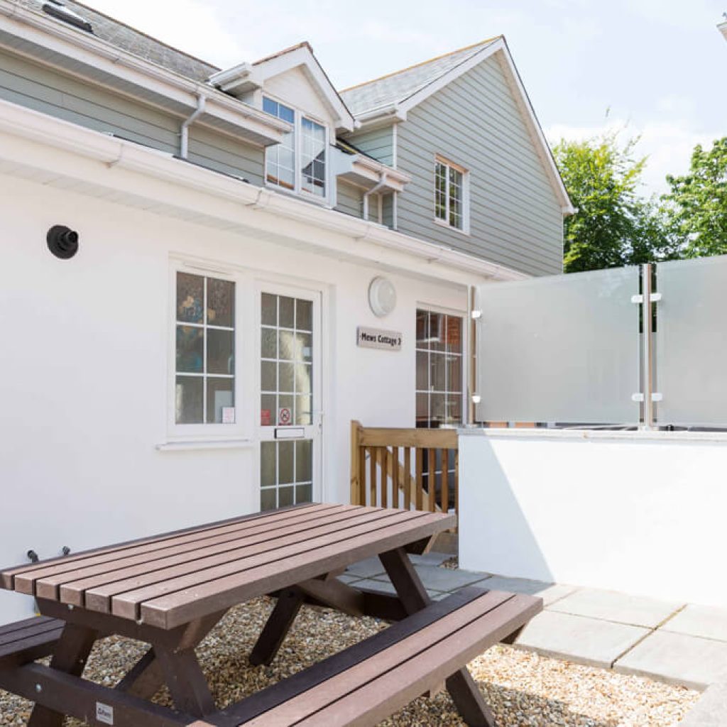 Oakcliff's Mews Cottage outdoor area/ Including the cottage itself and a picnic bench