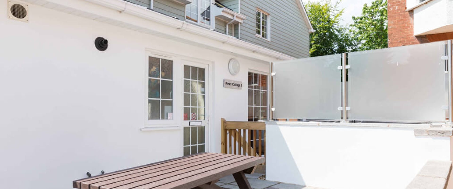 Oakcliff's Mews Cottage outdoor area/ Including the cottage itself and a picnic bench