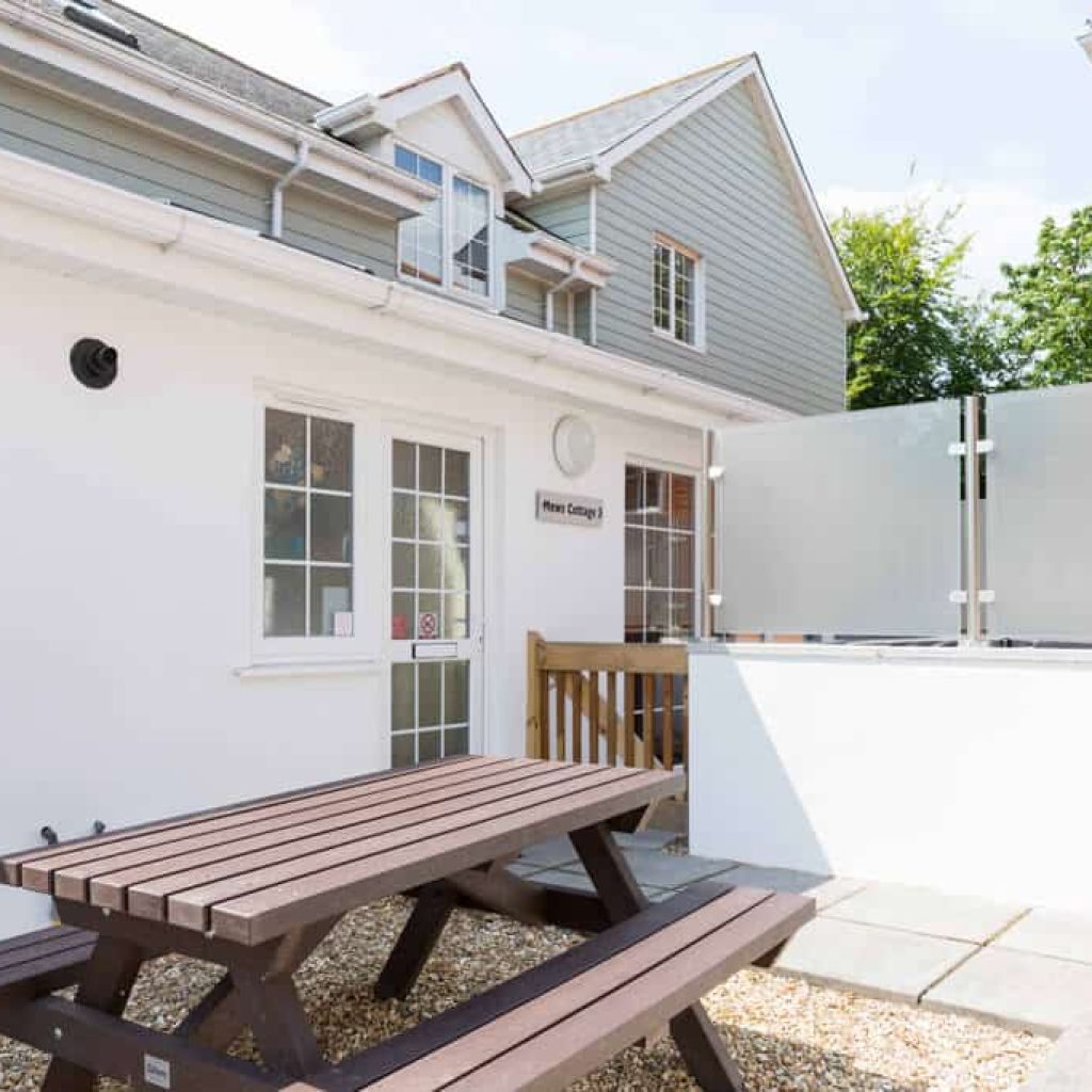 Oakcliff's Mews Cottage outdoor area/ Including the cottage itself and a picnic bench