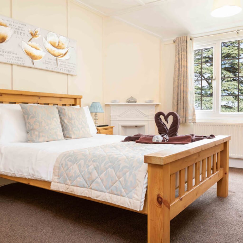 Oakcliff's Oak Cottage double bedroom. With a double bed and two towels in the shape of swans