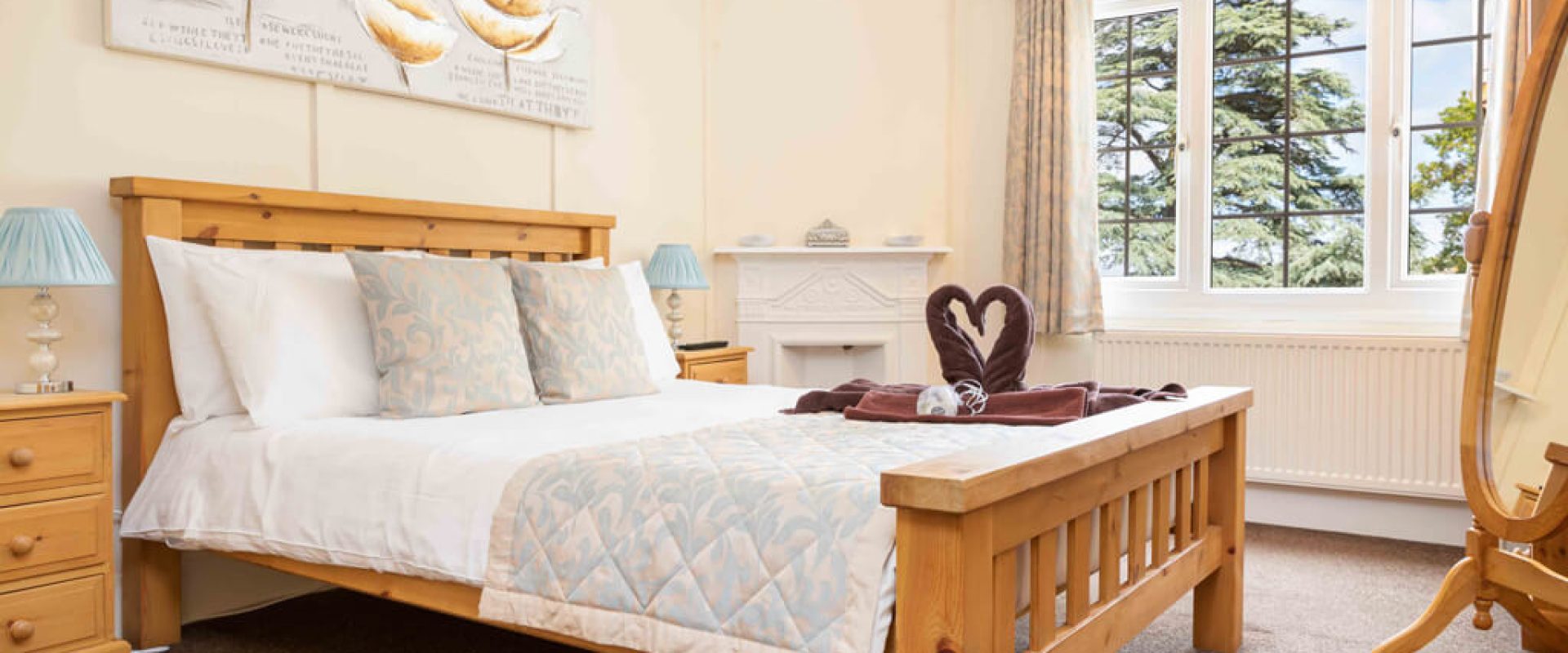 Oakcliff's Oak Cottage double bedroom. With a double bed and two towels in the shape of swans