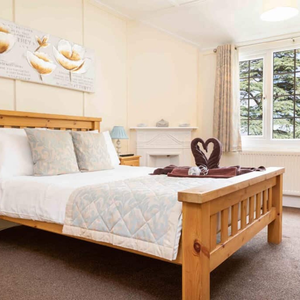 Oakcliff's Oak Cottage double bedroom. With a double bed and two towels in the shape of swans