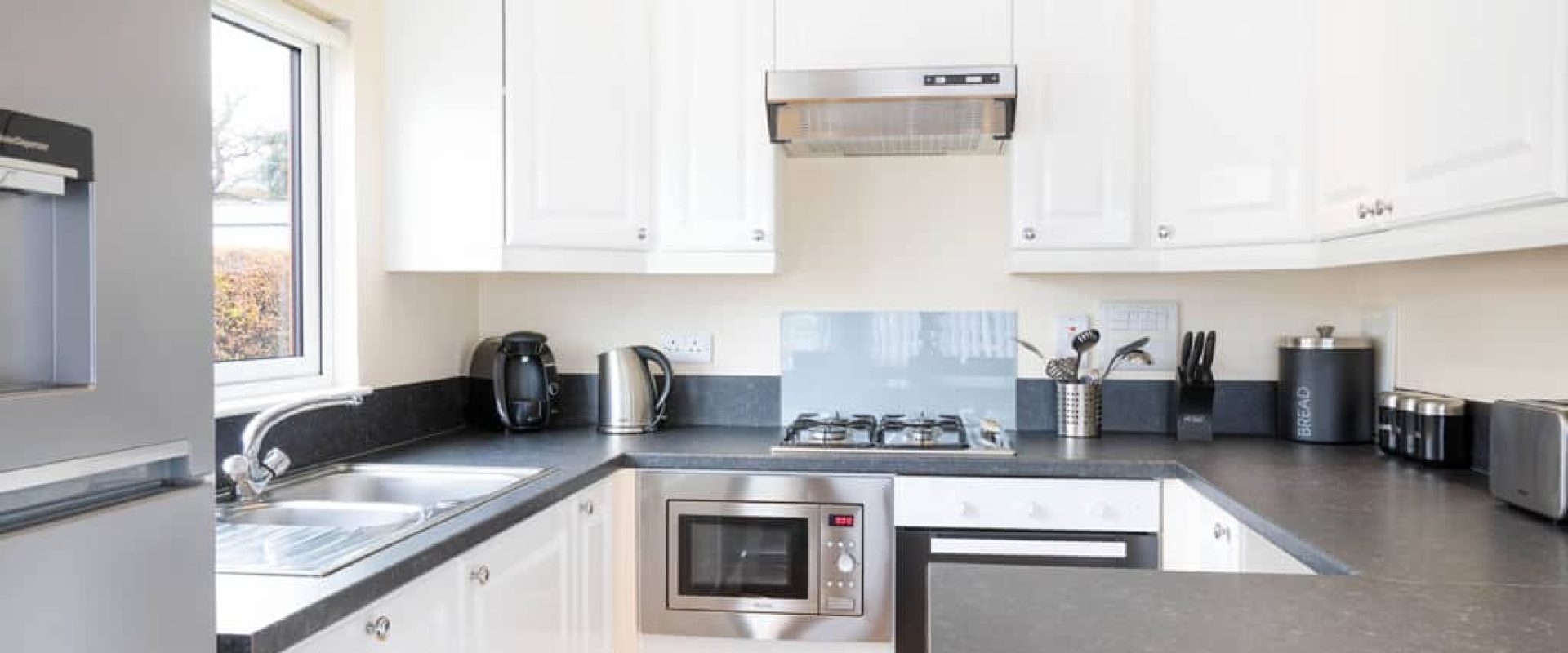Oakcliff's Oak Lodge grey and white kitchen with a peninsula.