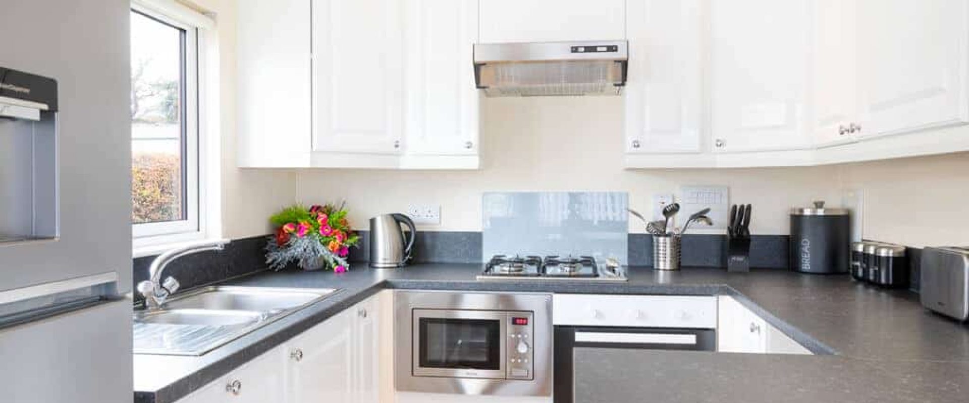 Oakcliff's Oak Lodge grey and white kitchen with a peninsula.