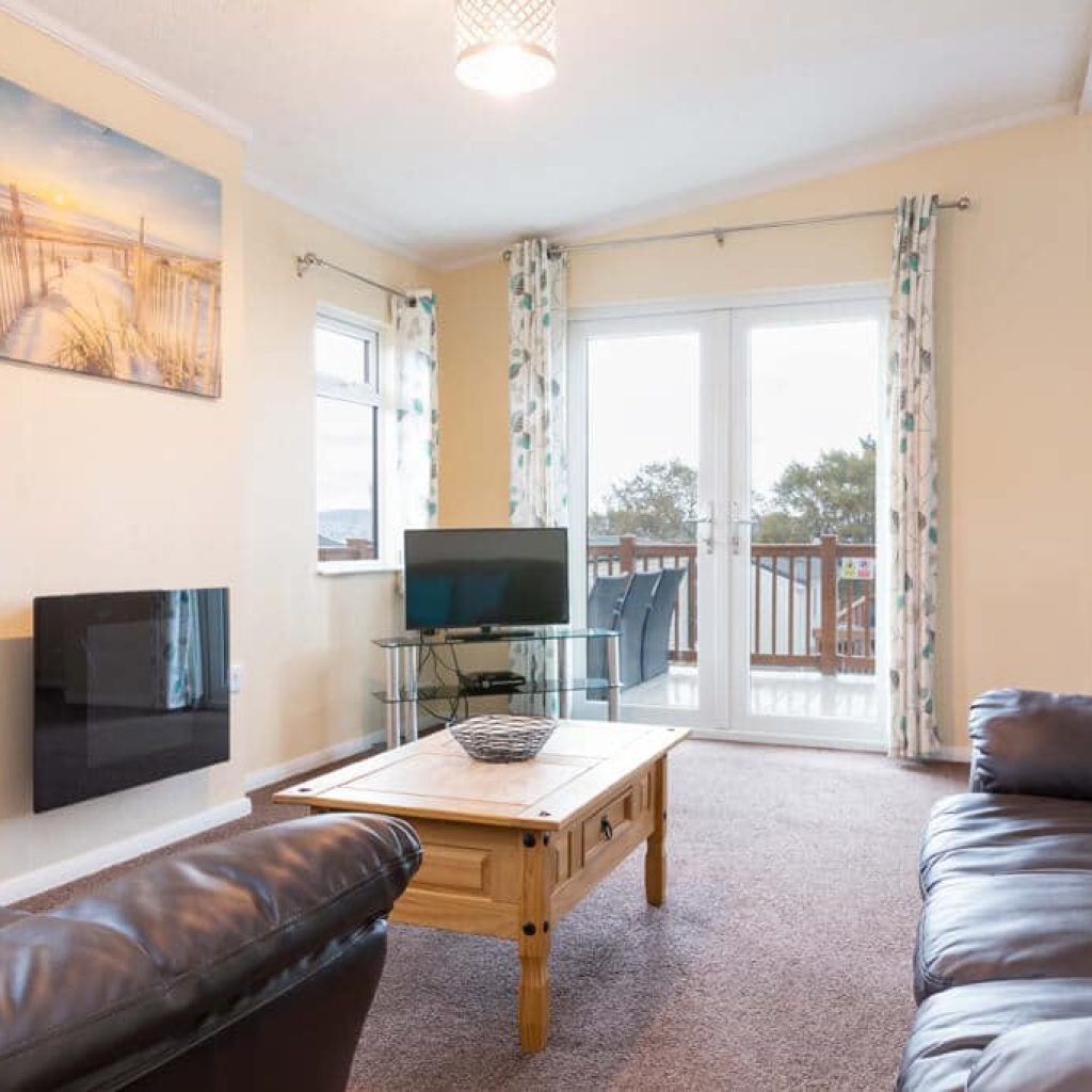Oakcliff's Oak Lodge living room. Including sofas, coffee table, modern fire and TV.