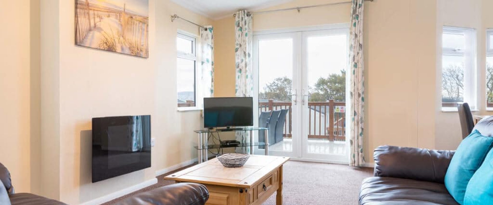 Oakcliff's Oak Lodge living room. Including sofas, coffee table, modern fire and TV.