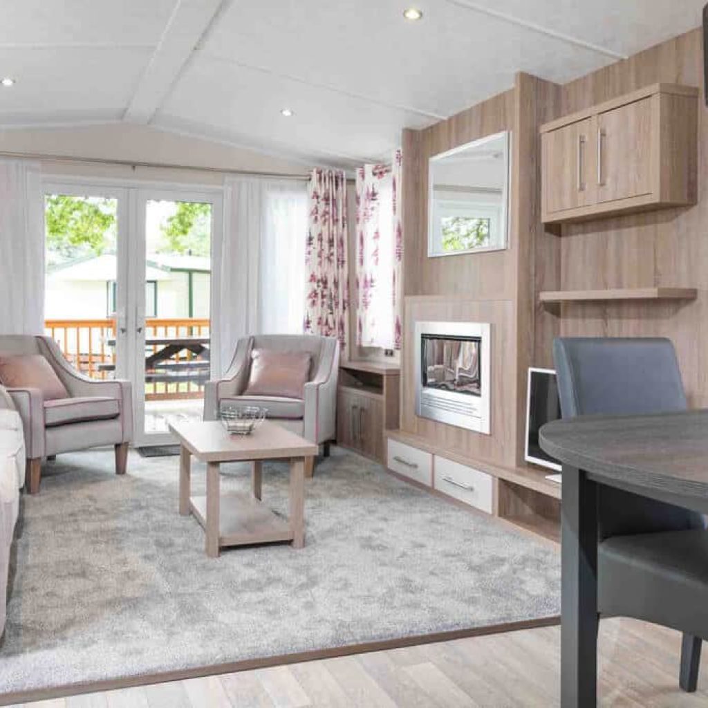 Oakcliff's Osprey Plus Mini Lodge open-plan living srea. Including multiple sofas/chairs and a dining table