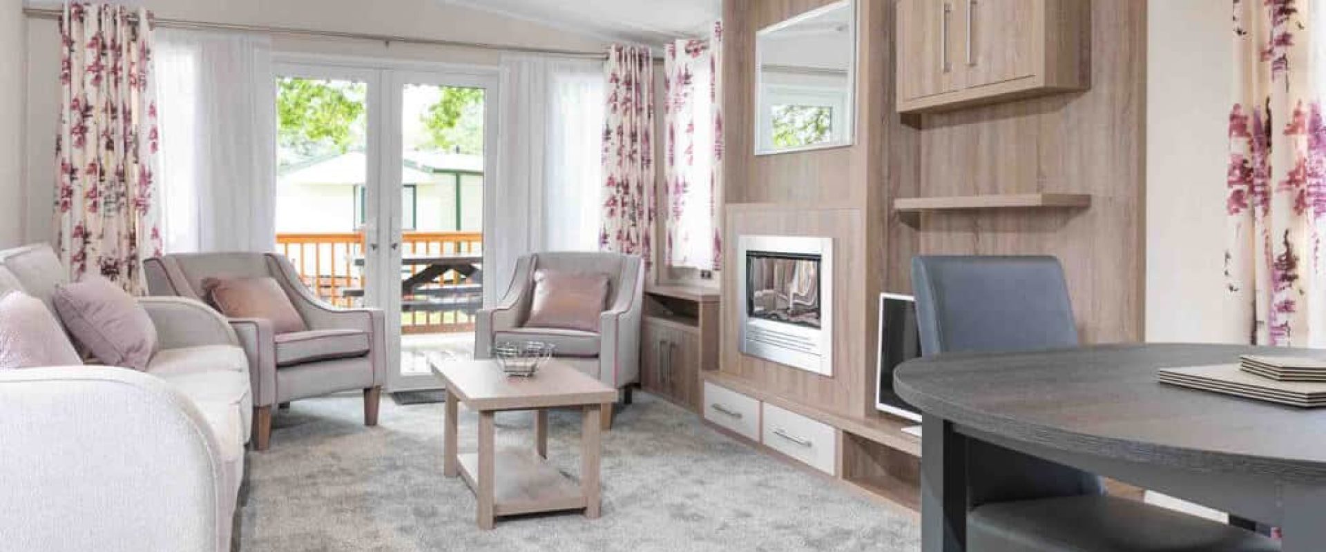 Oakcliff's Osprey Plus Mini Lodge open-plan living srea. Including multiple sofas/chairs and a dining table