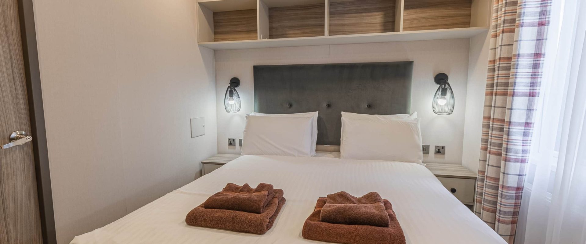Oakcliff's Lapwing Mini Lodge double bedroom with overhead storage