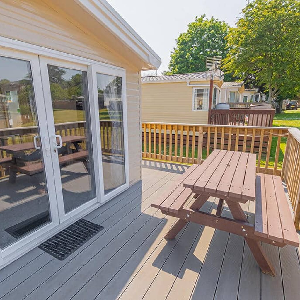 Oakcliff's Wren Plus Caravan private, outdoor decking, including a picnic bench.