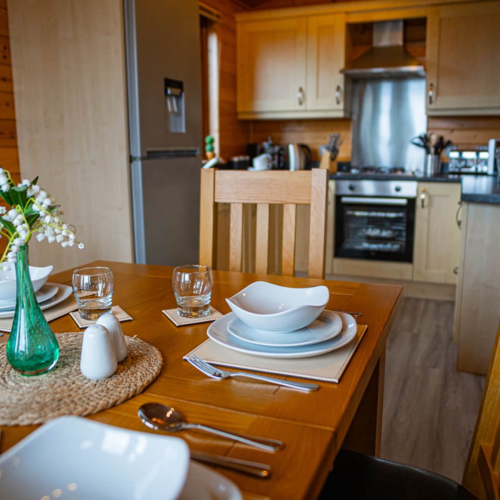 A set dining table with a kitchen in the background.
