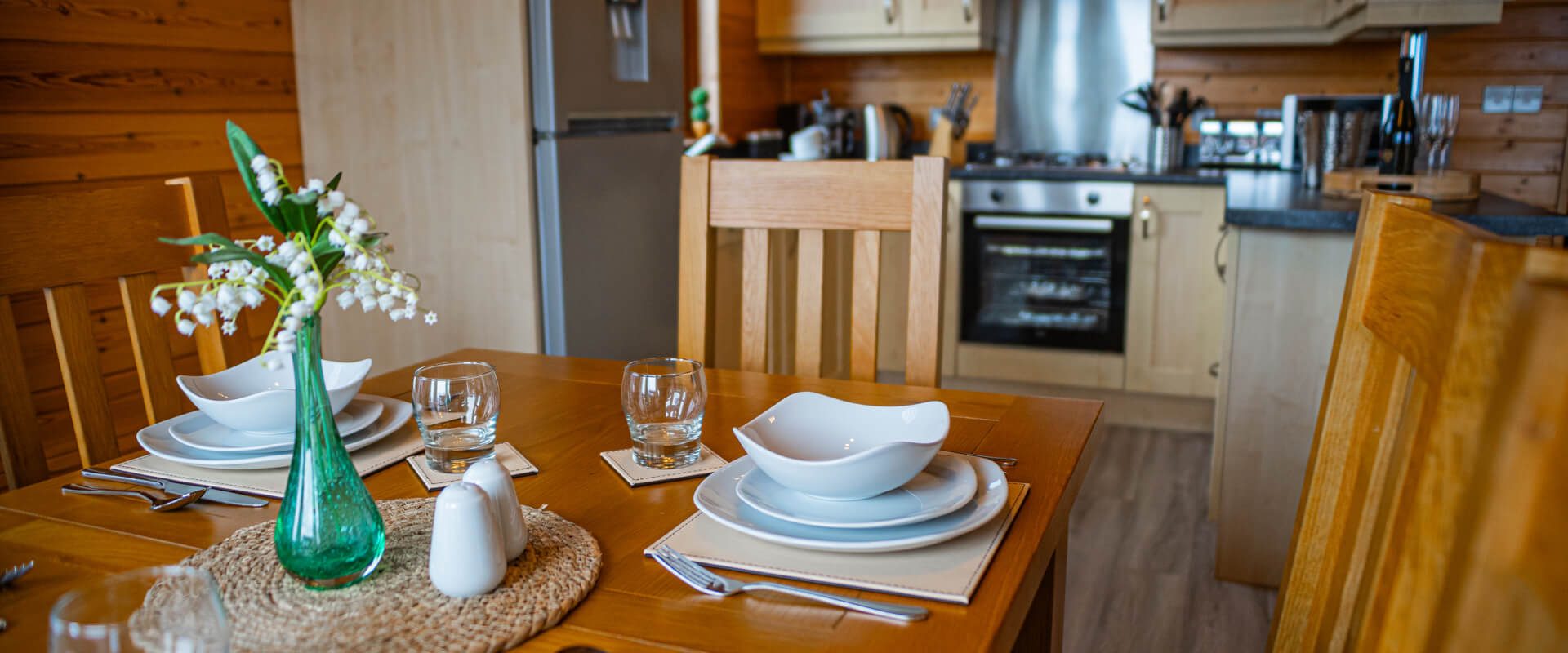 A set dining table with a kitchen in the background.