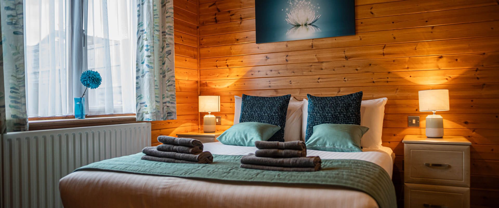 Oakcliff's Pine Lodge double bedroom. A warm, welcoming interior with plenty of natural light.