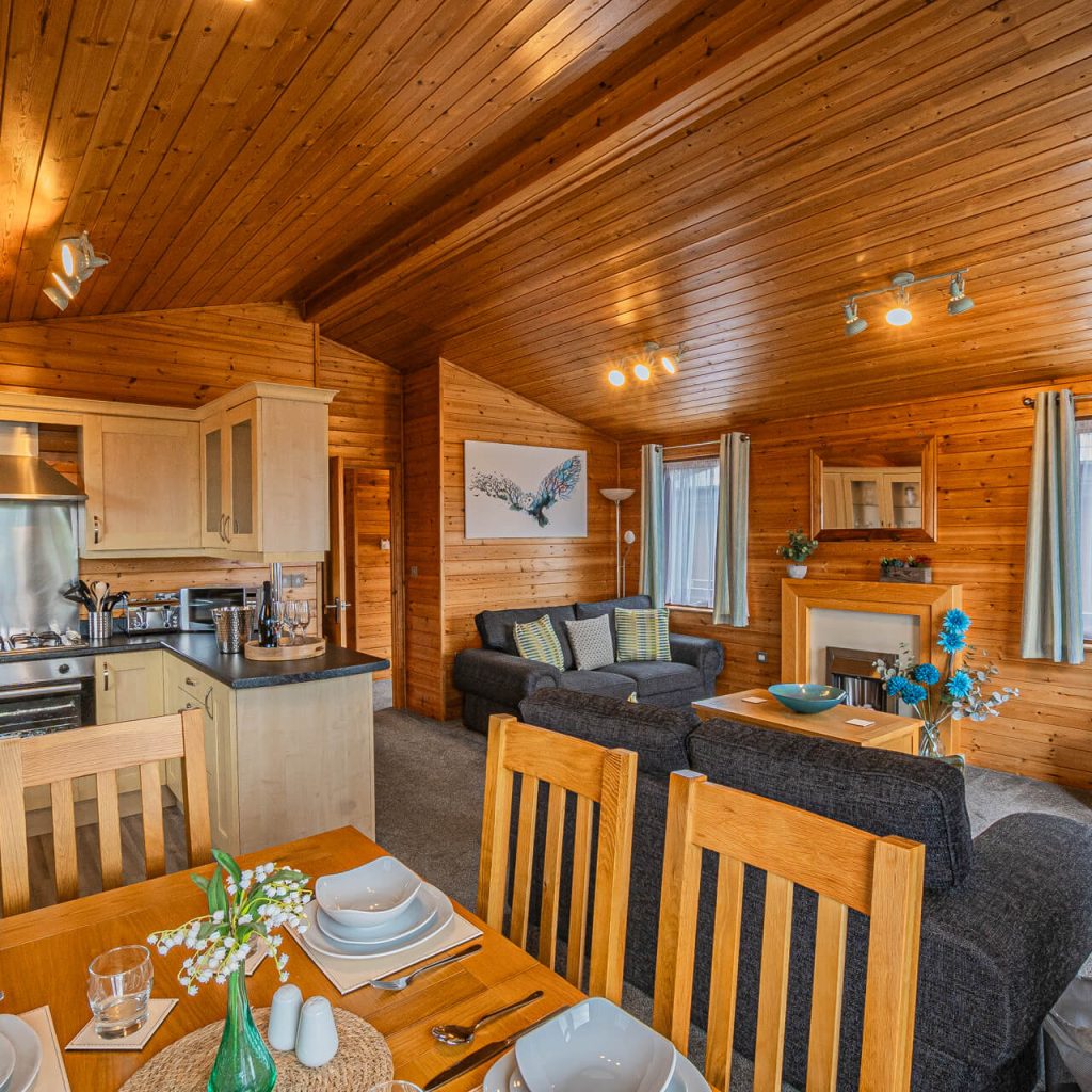Oakcliff's Pine Lodge open-plan living area. Including a dining section, kitchen and lounge,