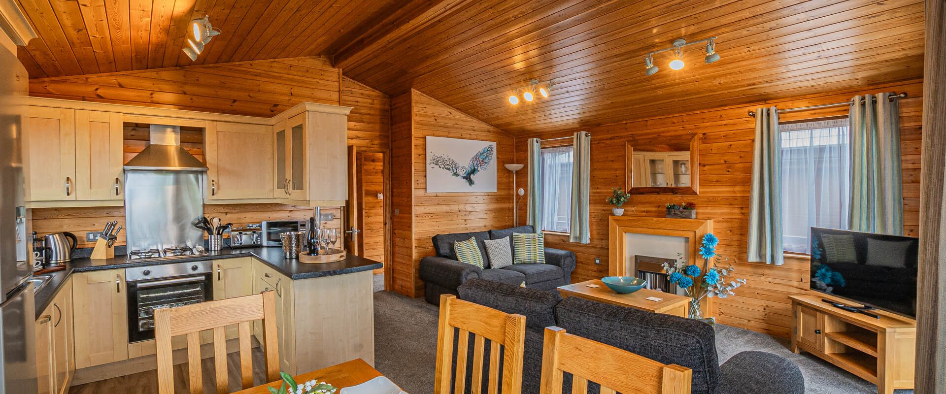 Oakcliff's Pine Lodge open-plan living area. Including a dining section, kitchen and lounge,