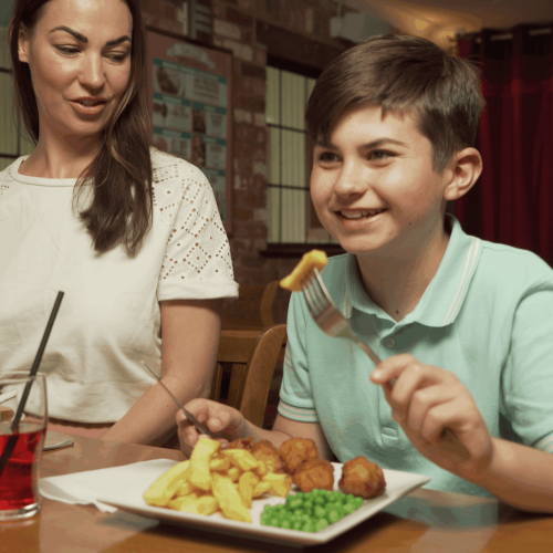 Mother and son eating food at Oceans Bar and Restaurant